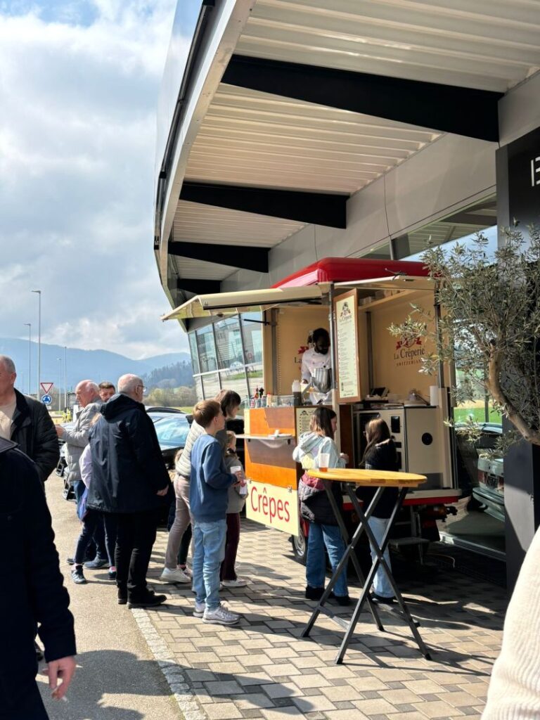 Stand de crêpes et visiteurs lors des portes ouvertes de Blank Automobile